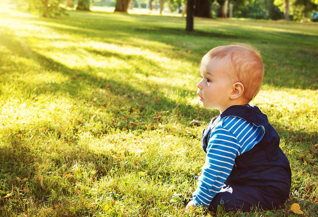 Dziecko siedzące na trawie 