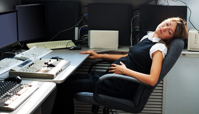 kobieta śpiąca przy komputerach